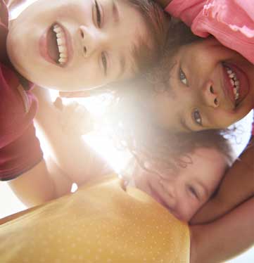 Three  happy children looking down at camera.